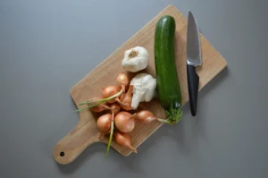 échalotte ail et courgette sur une planche à découper